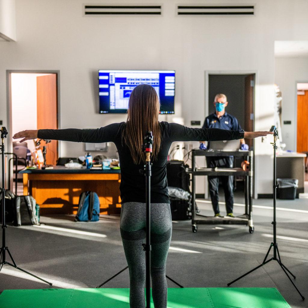 A student during a health science test standing with arms open 90 degrees from her body.