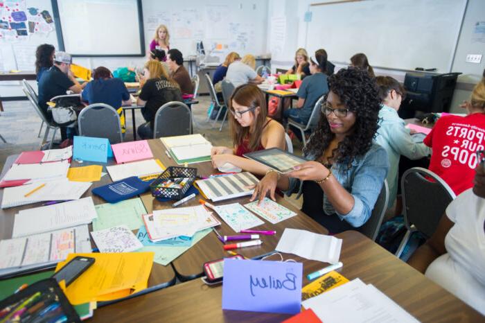 Students sitting a tables during a lecture.